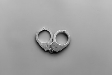 Metal handcuffs on grey background top view copy space