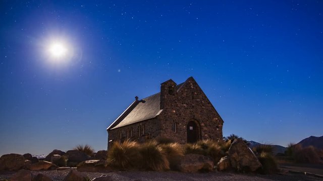 Timelapse of Church of the Good Shepherd at night with the Moon shining in the night sky and creating beautiful light. One of the most iconic views in New Zealand and major tourist attraction.