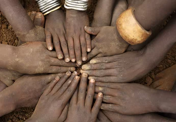 Foto auf Acrylglas African ceremony of the Mursi tribe, close-up of hands of a group of children, Ethiopia © Dietmar Temps