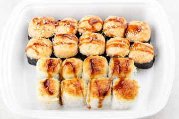 Sushi roll set in a white box. Hot baked rolls. Traditional Japanese food.