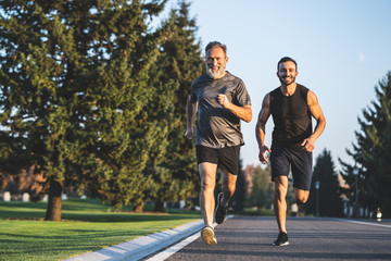 The happy father and a son running on a park road