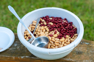 Soup ingredients. Plastic bowl with white and red beans.