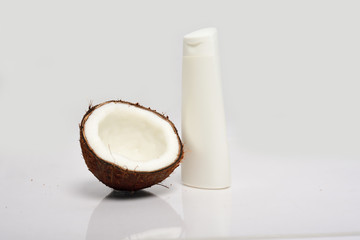 Close-up of Broken coconut and white bottle are isolated on white backgroun