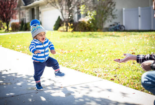 A Cute Little Africa American Little Boy Learning To Walk And Taking Big Steps With An Excited Expression On His Face. Walking Towards A Treat. Eyes On The Prize