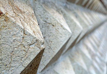 pyramid-shaped stones background on the border wall of the build