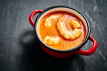 traditional Thai soup with shrimp and coconut milk in a red pot