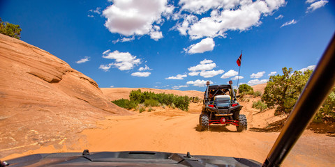 Off roading in Moab under blue sky with clouds © Jason
