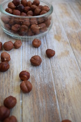 Hazelnuts in a glass jar and scattered nuts in the background of the tree. Copy space.