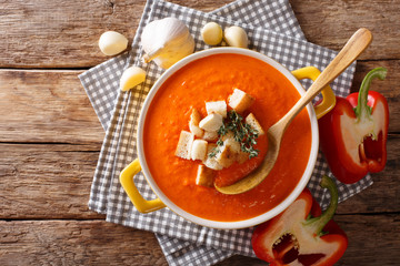 Traditional sweet pepper puree soup with croutons close-up. Horizontal top view