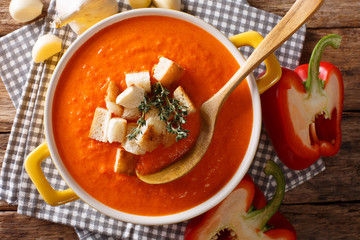 Dietary cream soup with sweet pepper and croutons close-up. Horizontal top view