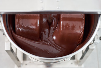 Melted chocolate being mixed in a stainless steel mixer