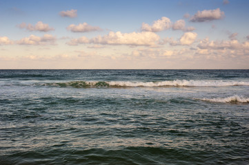 Obraz premium Big breaking Sea wave on a sandy beach on the shore of Sozopol in Bulgaria. Beautiful waves wash the beach with golden sand before sunset. Dramatic scene.