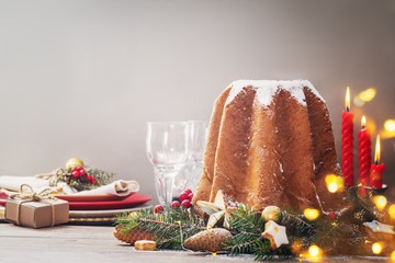 Pandoro - Italian christmas  sweet yeast bread on festive served plate on wooden table. With free text space.