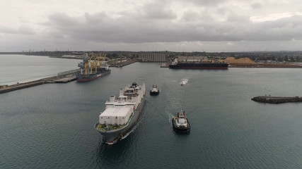 Livestock ship leaving Port of Portland assisted by two tug boats.