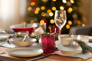 christmas, holidays and table setting concept - glass and tableware for festive dinner at home