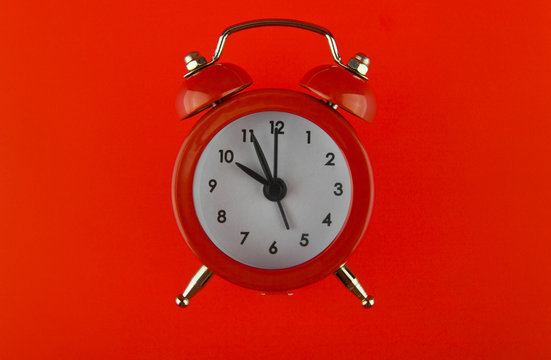 red alarm clock on red background
