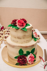 Bunk cake with white cream and flowers. The wedding cake. Candy bar. Bakery card