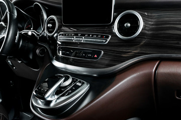 Modern Luxury car inside. Interior of a car. Comfortable leather seats. Brown perforated leather cockpit with white stitching. Steering wheel and dashboard. Automatic gear stick shift. Car detailing