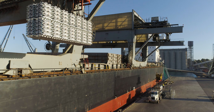 Drone tracking backwards on aluminum ingots being loaded on a ship from export from Australia 