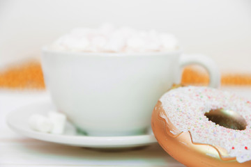 Fototapeta na wymiar hot chocolate with marshmallow candy and Christmas decorations in the form of a donut on a white wooden background. Copy space