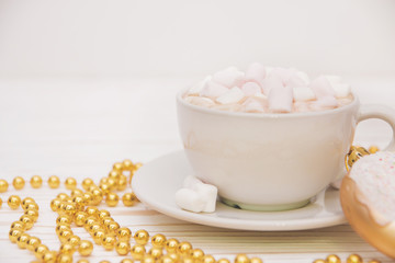hot chocolate with marshmallow candy and Christmas decorations on a white wooden background