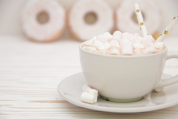 hot chocolate with marshmallow candy and Christmas decorations on white wooden background