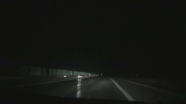 Car Driving in Night on the a Highway with Big Speed and Headlights On 