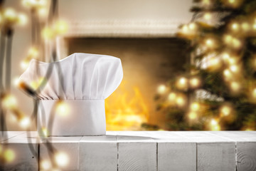 White cook hat on white wooden table and christmas decoration. Free space for your products. 