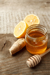 Composition with honey, lemon and ginger as natural cold remedies on white wooden background, flu remedy warming drink