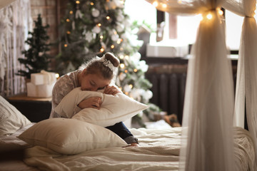 Obraz premium Teenager girl with pillows on bed in real bedroom