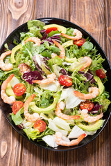 Mix of salad with shrimps , avocado and cherry tomatoes . Healthy food background