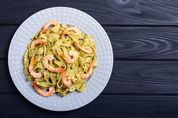 Pasta tagliatelle with sauce pesto and shrimps . Italian food background