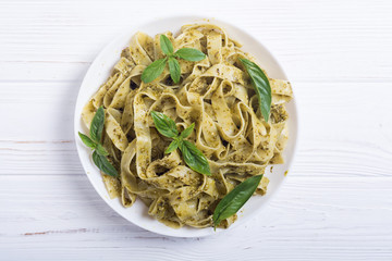 Pasta tagliatelle with green sauce pesto . Italian food background