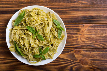 Pasta tagliatelle with green sauce pesto . Italian food background