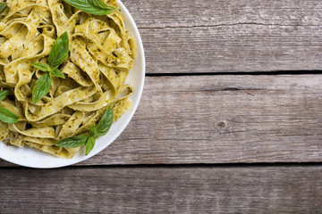 Pasta tagliatelle with green sauce pesto . Italian food background