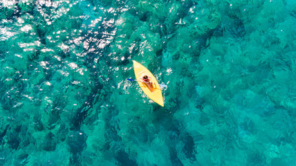 Fototapeta na wymiar Woman swims on a sports kayak in an exotic turquoise clear ocean. in the Blue Lagoon. View from above. Aerial view from a bird's eye view from a drone