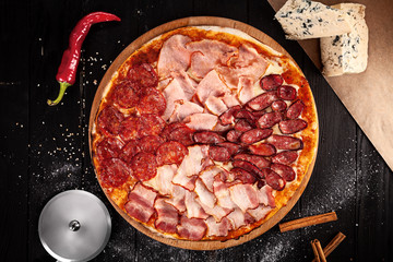Meat pizza on dark wooden background. Top view, copy space for text, logo or brand. Picture for recipes or books. 