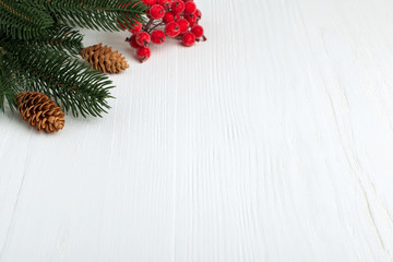 Christmas tree, red berries on a white wooden table. Copy space.