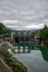 Fototapeta na wymiar Huge concrete dam on emerald colorful river