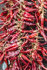 A bunch of red chili paprika hangs on a rope. Hot pepper is popular spicy for food, and favorite...