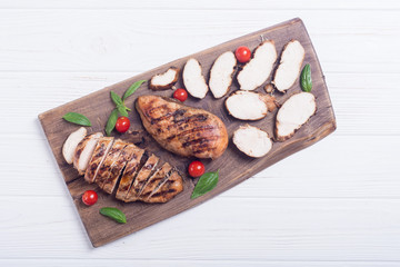 Grilled chicken breast ( fillet ) with basil and tomatoes