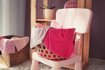 Laundry basket with dirty clothes on chair