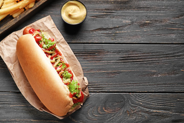 Tasty hot dog on wooden table