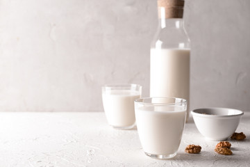 Glasses and bottle of tasty milk on white table