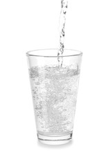 Pouring of mineral water in glass on white background