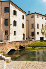 Fototapeta na wymiar Treviso, Italy August 7, 2018: the river flows among the old buildings of the city.