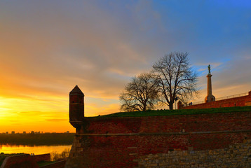 Fantastic colorful sunset with Old castle stone brick walls,  ruins, green grass park in the Kalemegdan fortress Belgrade Serbia 