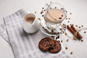 Cup and jug with tasty aromatic coffee and cookies on white table