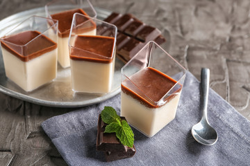 Glasses with tasty chocolate panna cotta on grey table