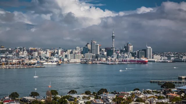 Cityscape of Auckland, New Zealand from Mount Victoria. Busy harbor and the city centre with its most iconic buildings. Dramatic cloudscape. Timelapse video.